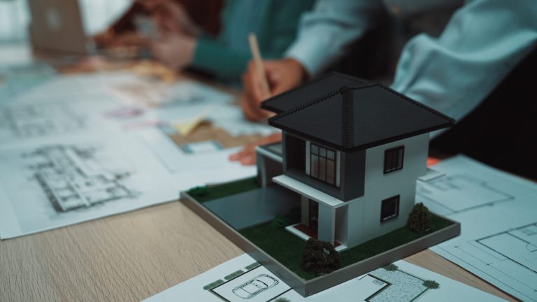 Architectural Design Process with 3D Model of Modern House and Blueprints on Table